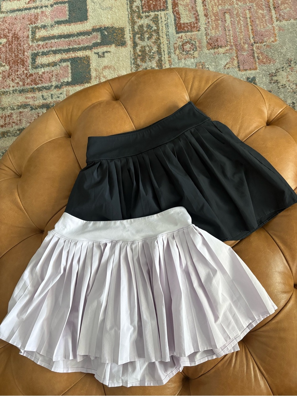 Bundle of two pleated athletic skirts.
